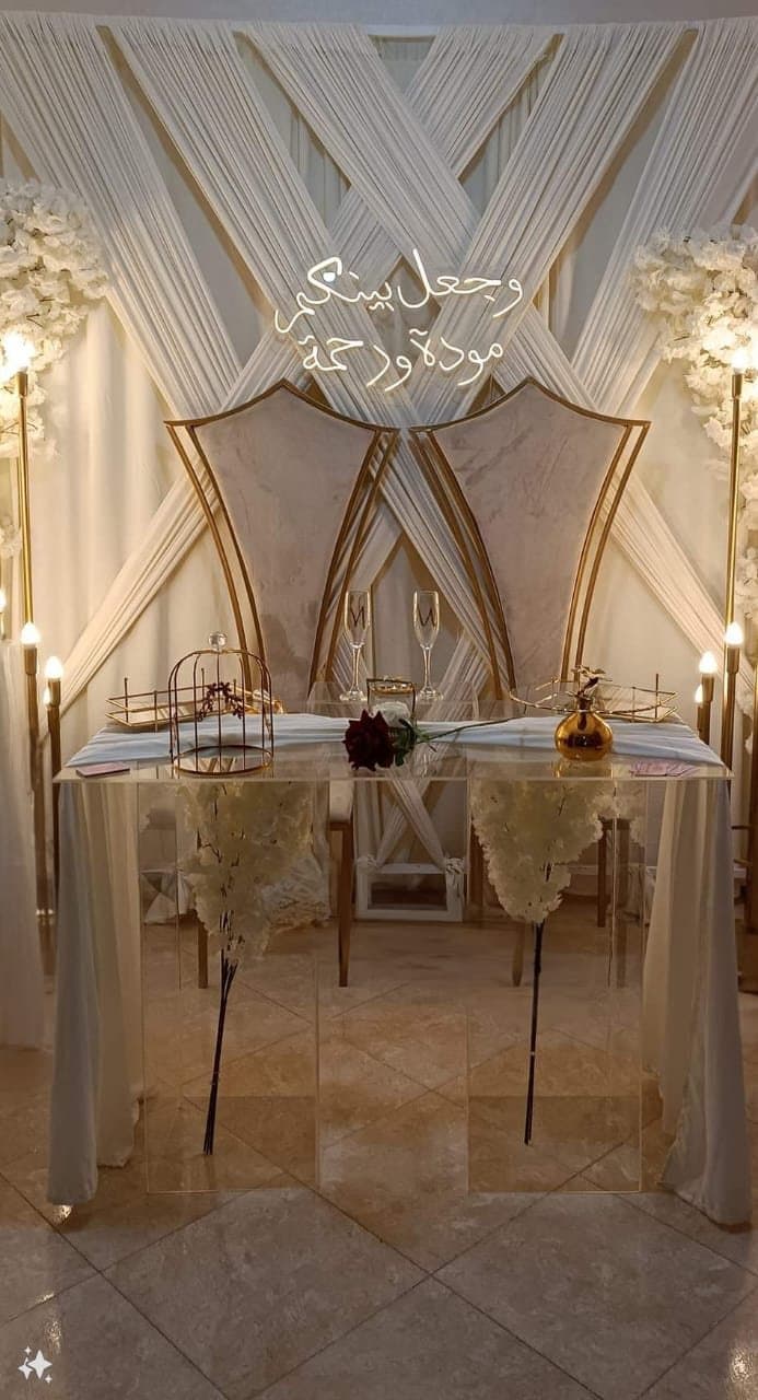 Table d'honneur sous une arche drapée pour des fiançailles